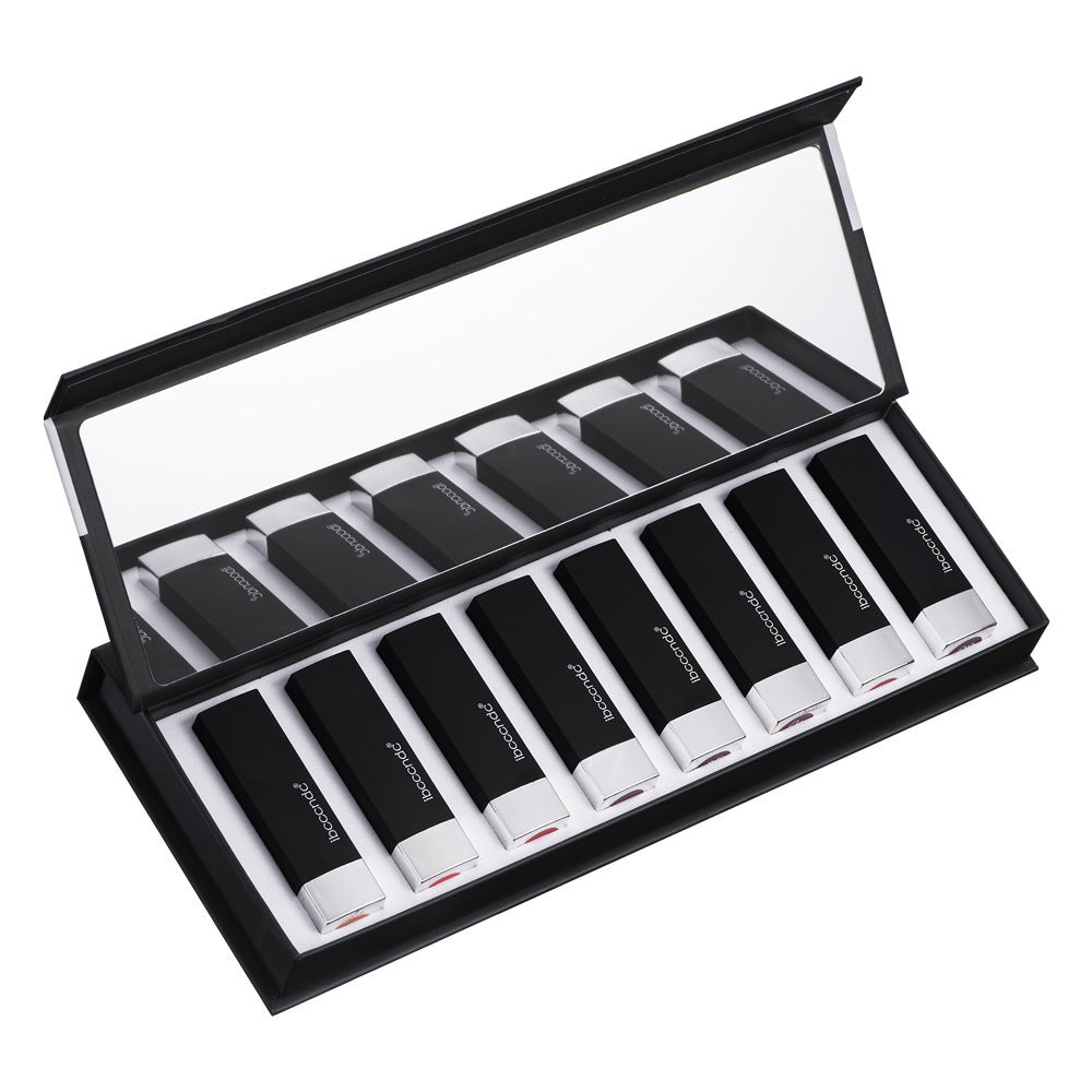 Set of black lipsticks with visible brand name in a display case on a white background