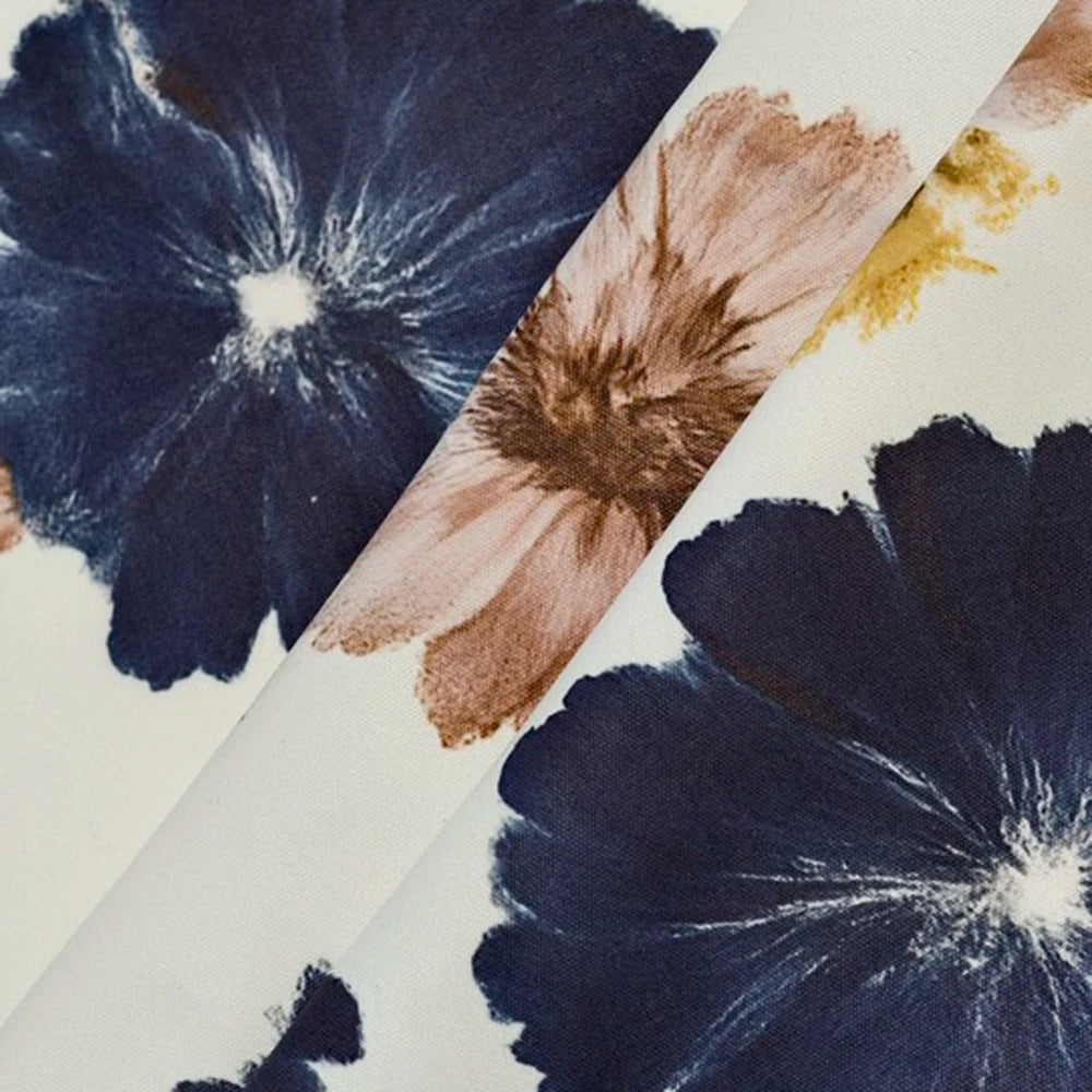 Close-up of floral patterns on fabric swatches in navy, brown, and gold.