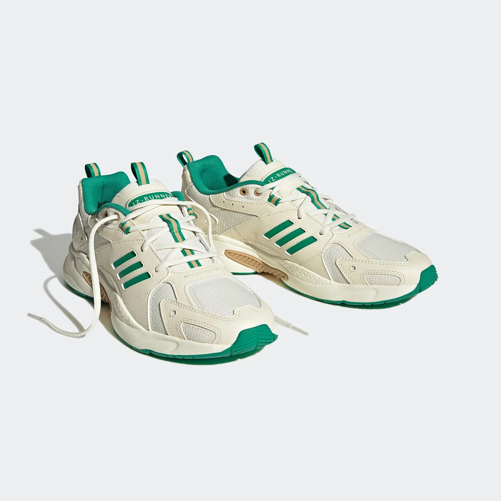 White sneakers with green accents on a light gray background