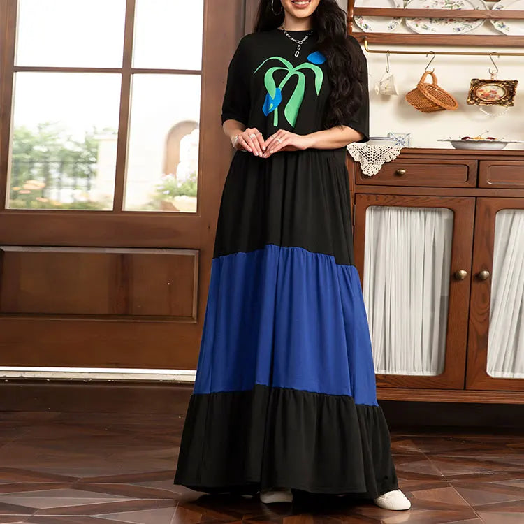Woman wearing a black and blue dress with a kitchen in the background