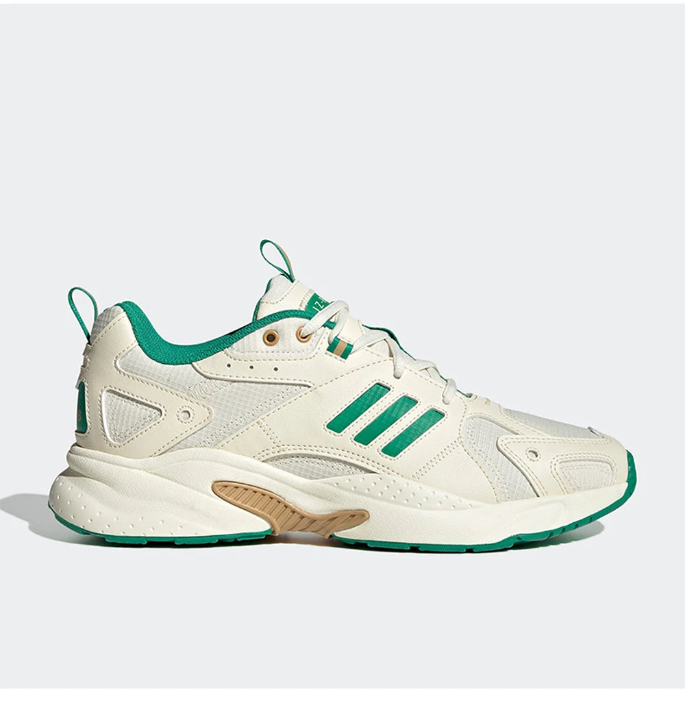 White and green sneaker with Adidas logo on a light gray background