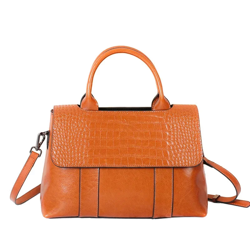 Brown leather handbag with a strap on a white background