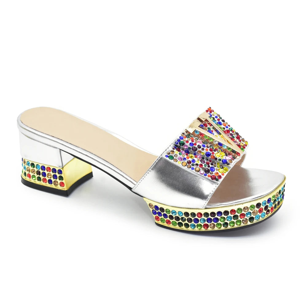 Silver sandal with colorful rhinestone embellishments on a white background