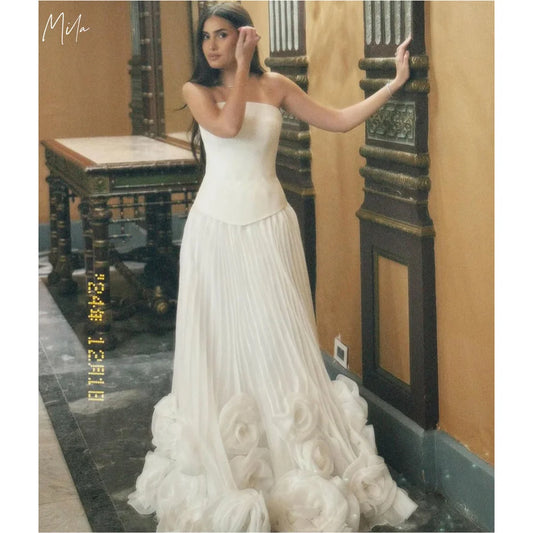 فساتين حفلات ميلا وايت بدون حمالات بتصميم حرف A، فساتين سهرة من التول مزينة بأزهار ثلاثية الأبعاد، فساتين حفلات موسيقية مخصصة بطول الأرض ومزينة بثنيات