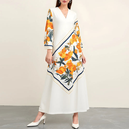 Woman wearing a white dress with a floral pattern draped over her shoulders against a plain background