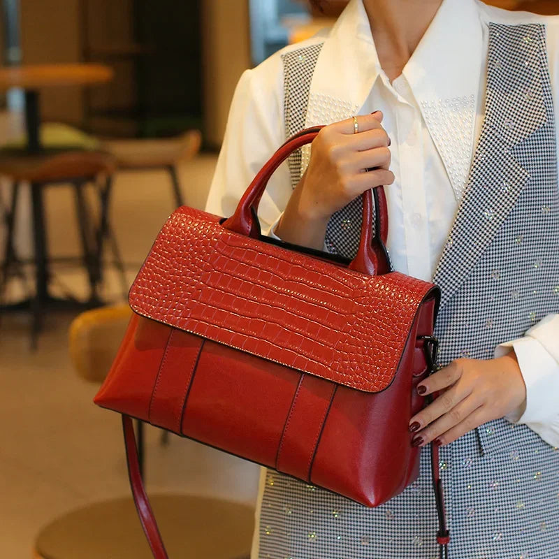 Person holding a red handbag in an indoor setting
