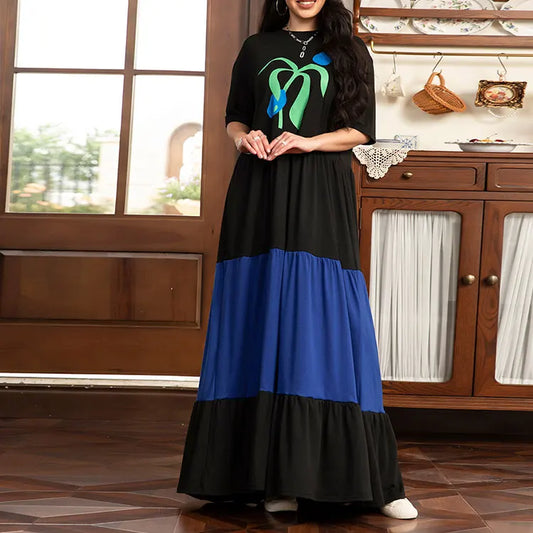 Woman wearing a black and blue dress with a kitchen in the background