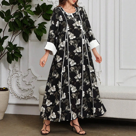 Woman wearing a black floral dress with white accents in an elegant room.