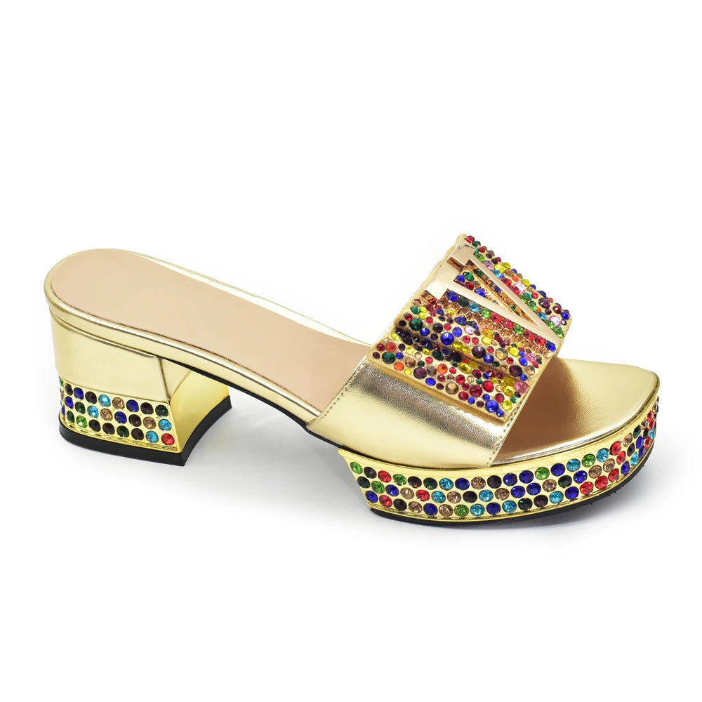 Gold sandal with colorful rhinestones on a white background